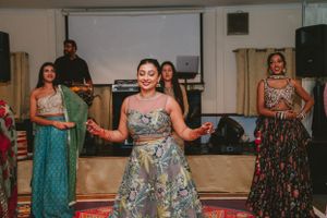 Group performing a choreographed dance routine in elegant formal wear on a patterned carpet.