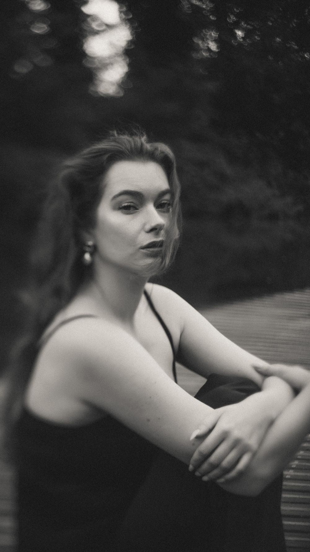 Moody black and white close-up portrait showing dramatic shadows and contemplative pose.