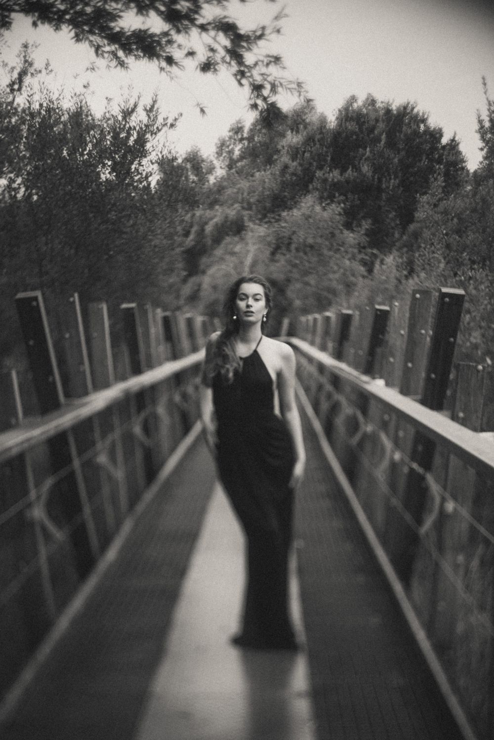 Dramatic black and white photo on wooden bridge with artistic blur effect.