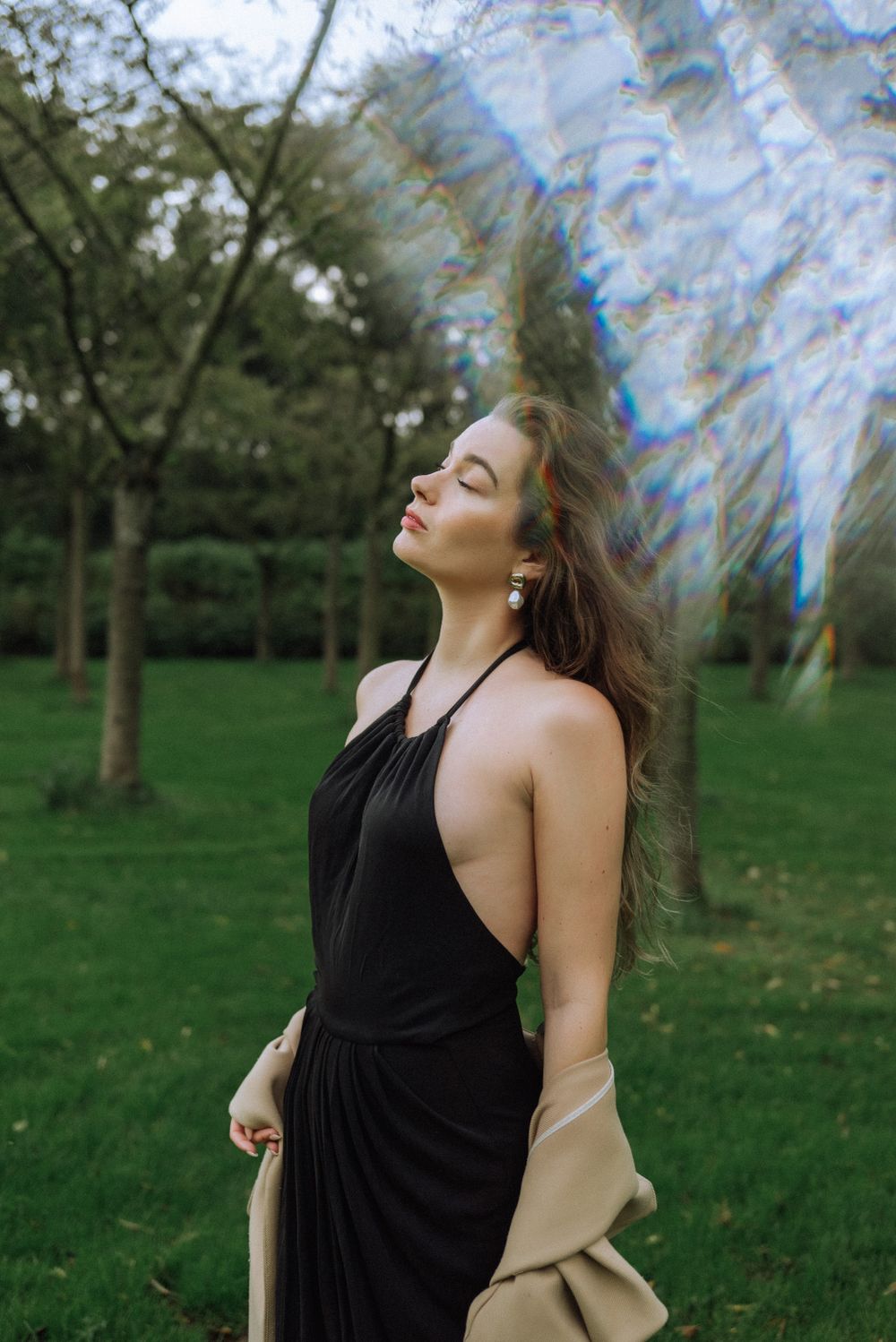 Ethereal outdoor photography in a black dress among spring trees.
