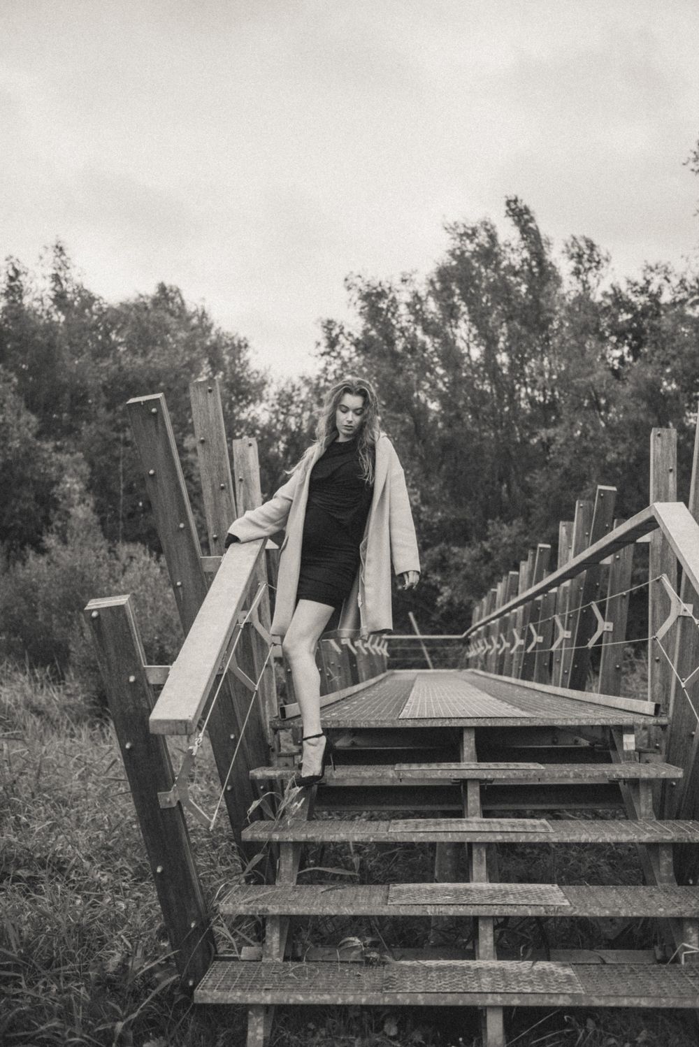 Dramatic black and white portrait series on elevated wooden platforms.