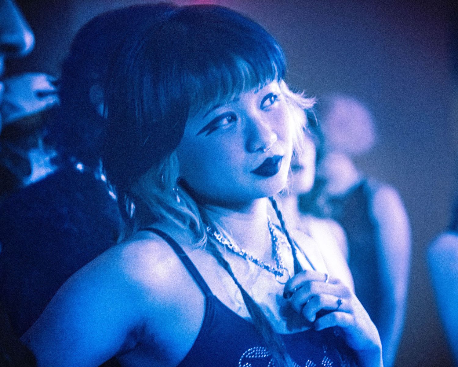 Girl in punk attire watches bands perform at the blue room