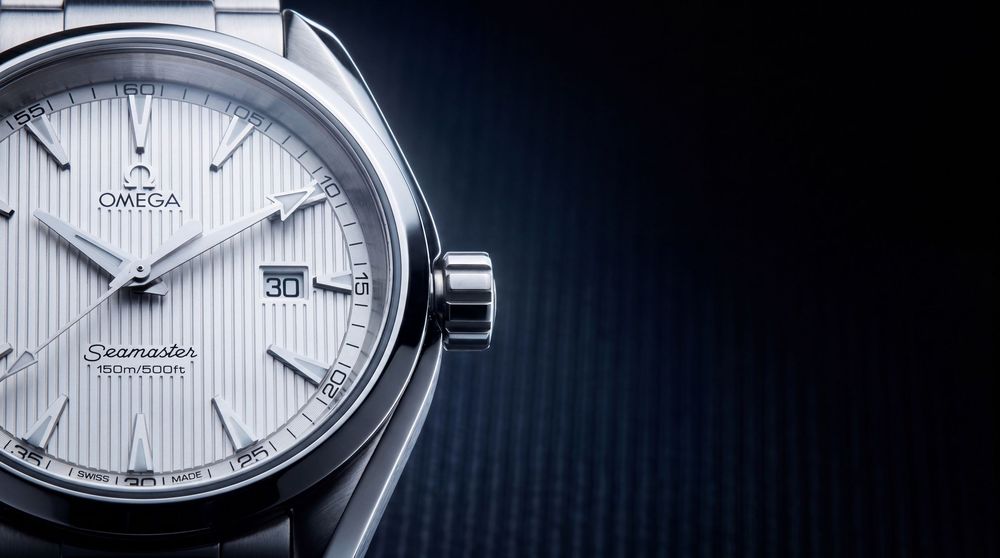 Omega Seamaster Aqua Terra luxury watch with silver dial and bracelet on dark background.