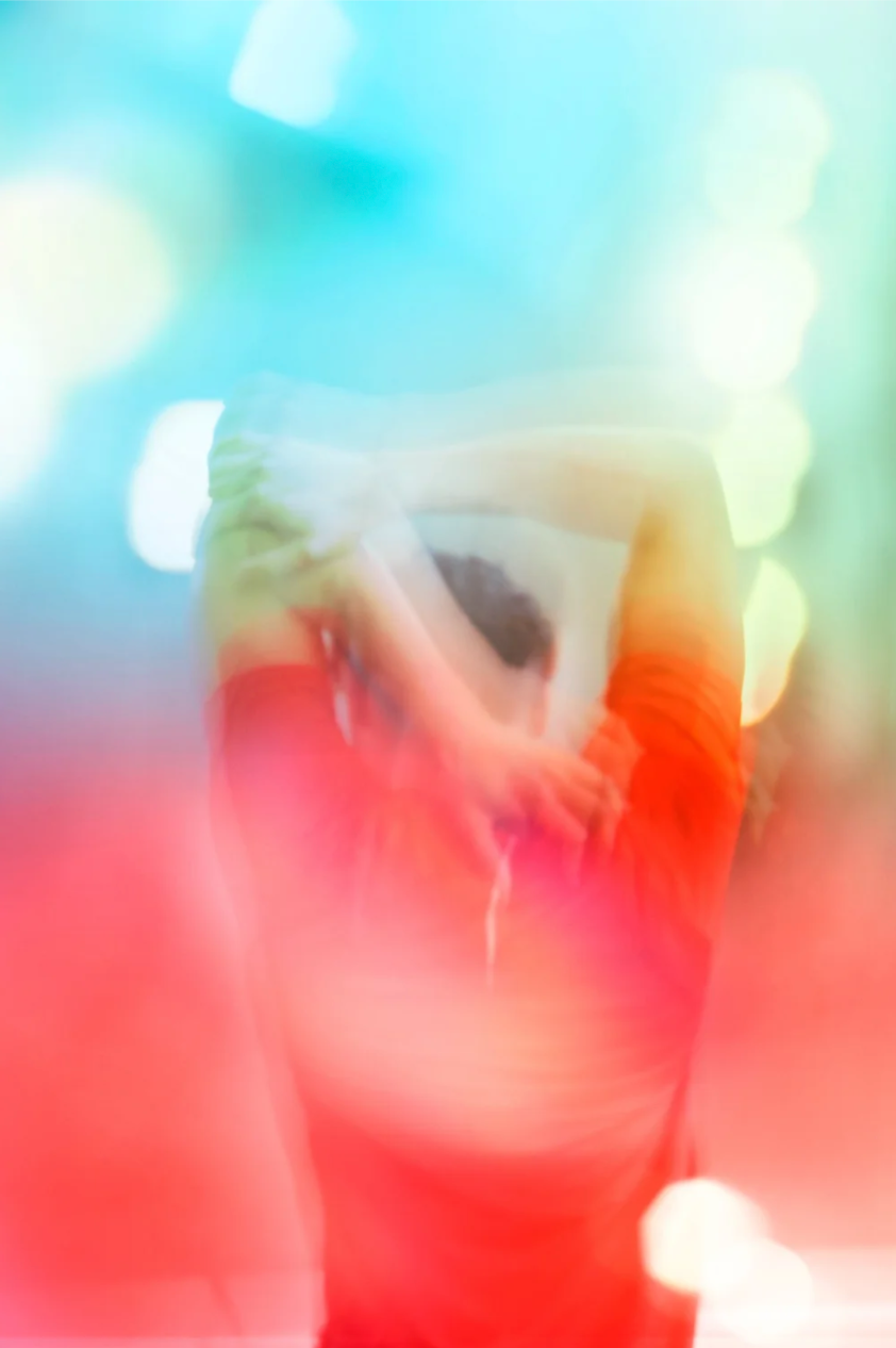 Abstract blurred background with gradient transition from bright turquoise blue to vibrant coral red colors.