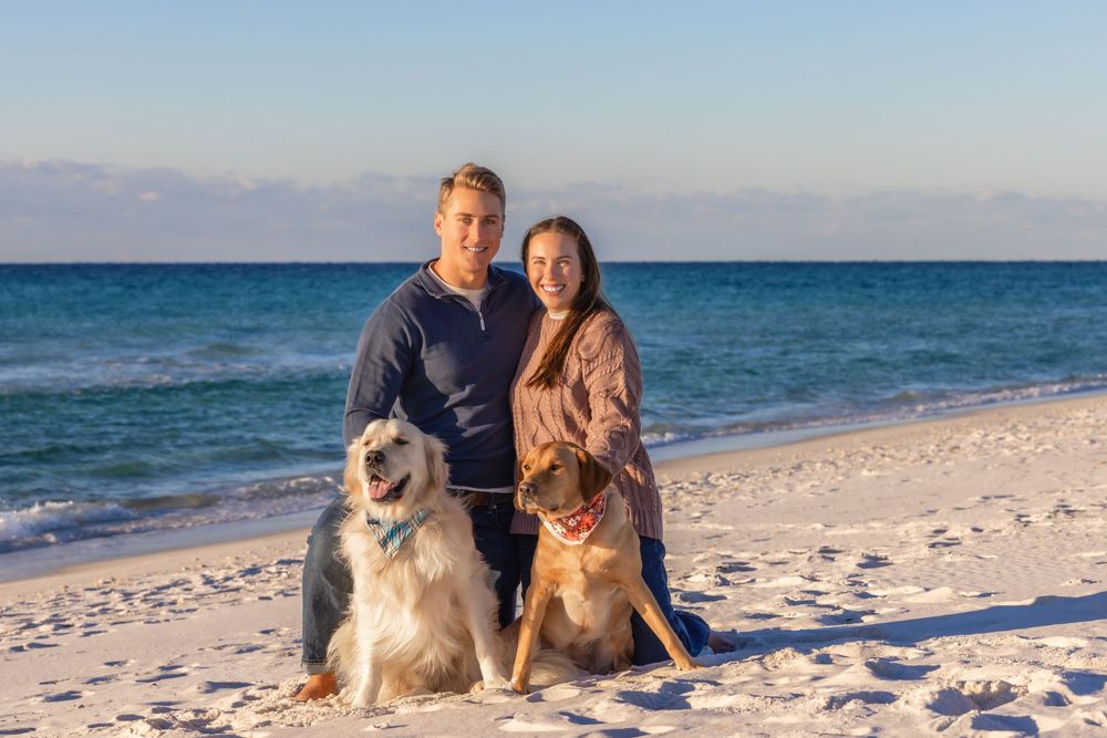 Group enjoying a sunny day at a white sandy beach with turquoise ocean waters in the background.