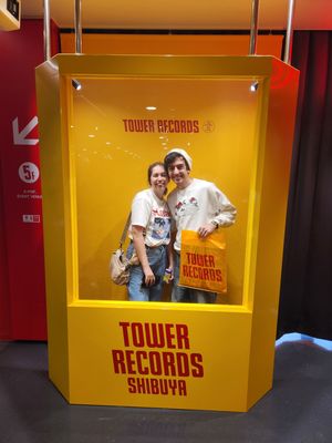 Yellow display windows at Tower Records Shibuya store with illuminated signage and branding.