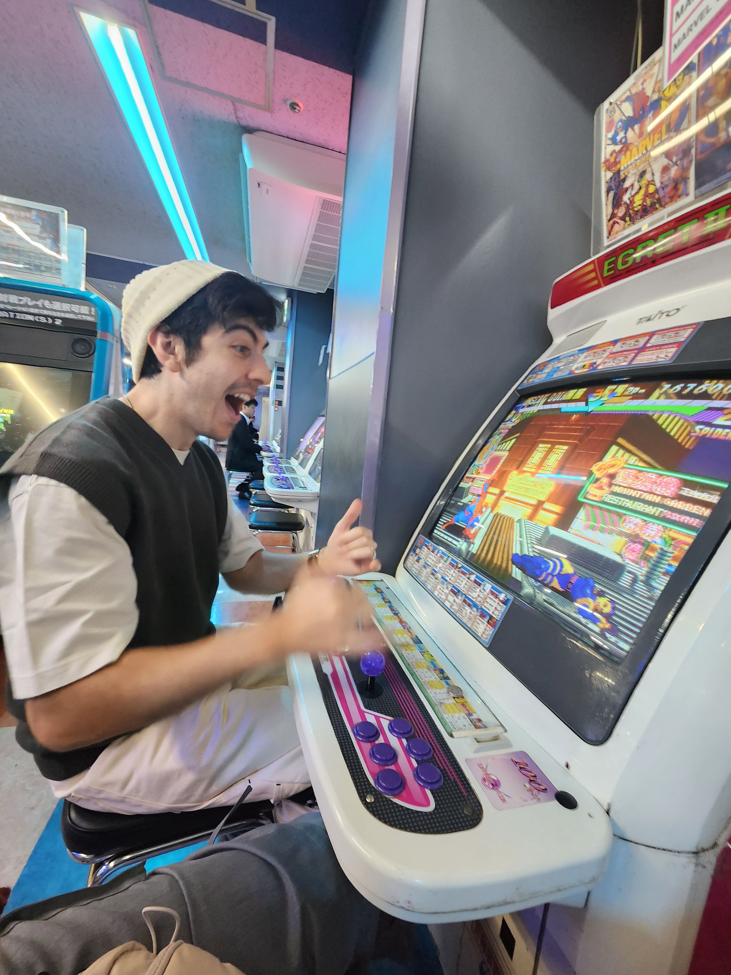 A player engages with a classic arcade cabinet game featuring neon blue lighting and retro gaming controls.