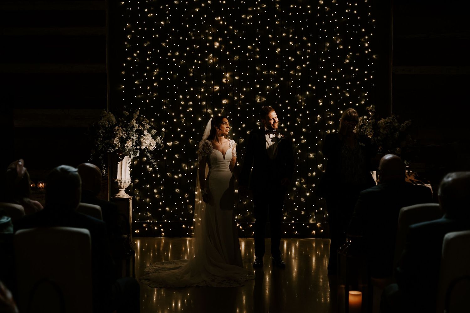 Romantic wedding couple poses against a magical starlit backdrop creating an ethereal nighttime atmosphere.