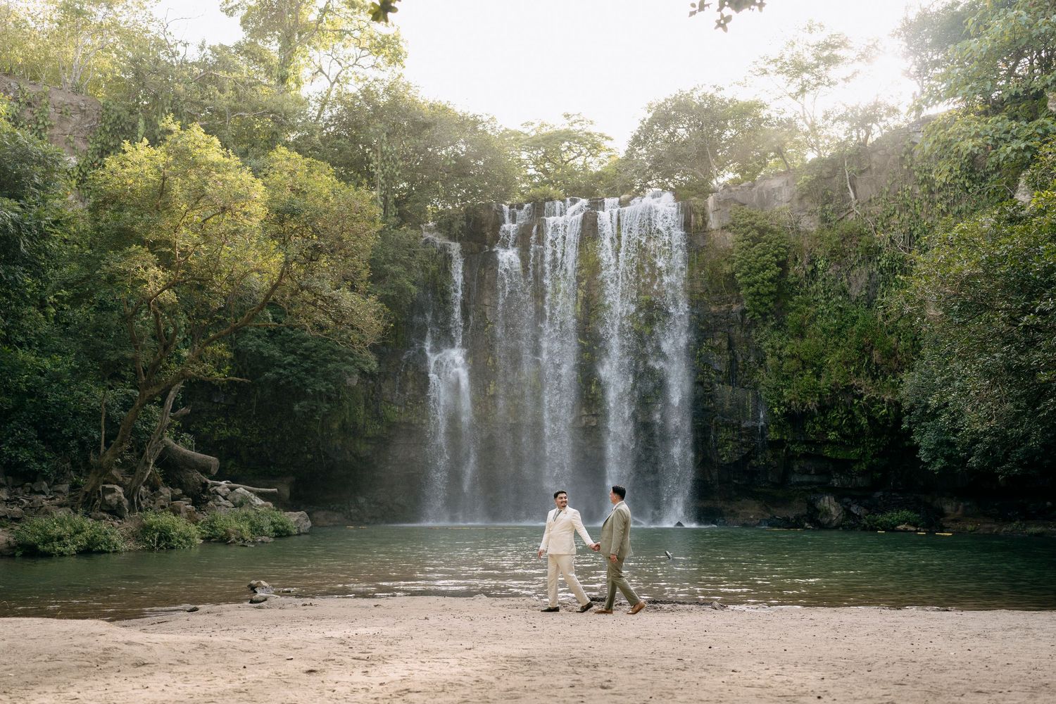 Romantic couple at the base of Llanos de Cortés Waterfall, Costa Rica.