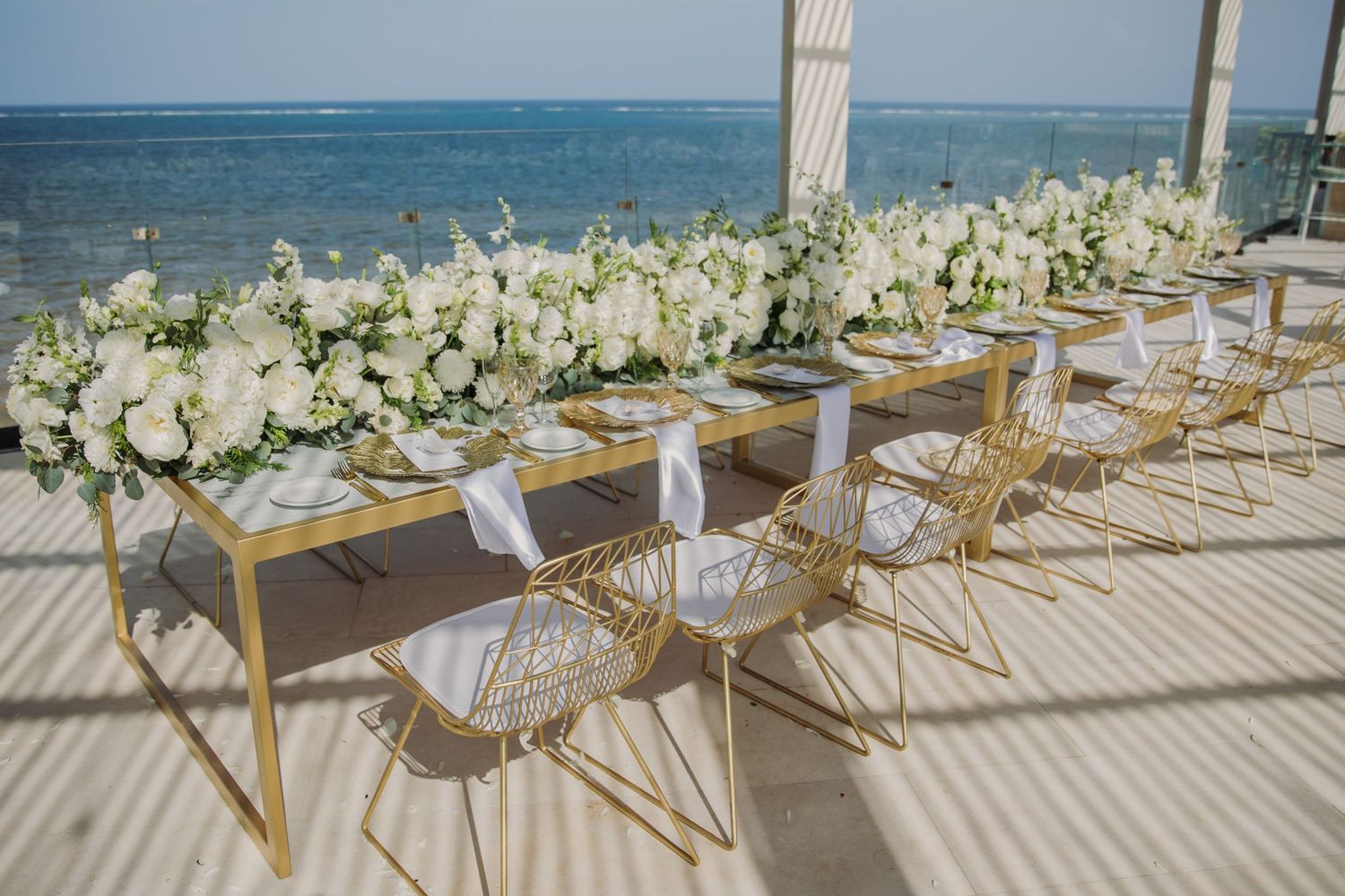 Elegant beach wedding reception setup with white floral centerpieces Dreams Sapphire Riviera Maya Wedding Photography
