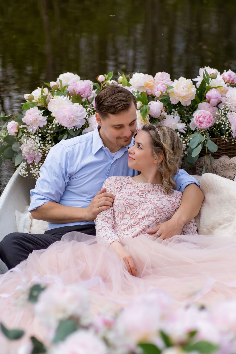 A romantic outdoor photo session with pink floral decor and a flowing blush gown against a natural backdrop.