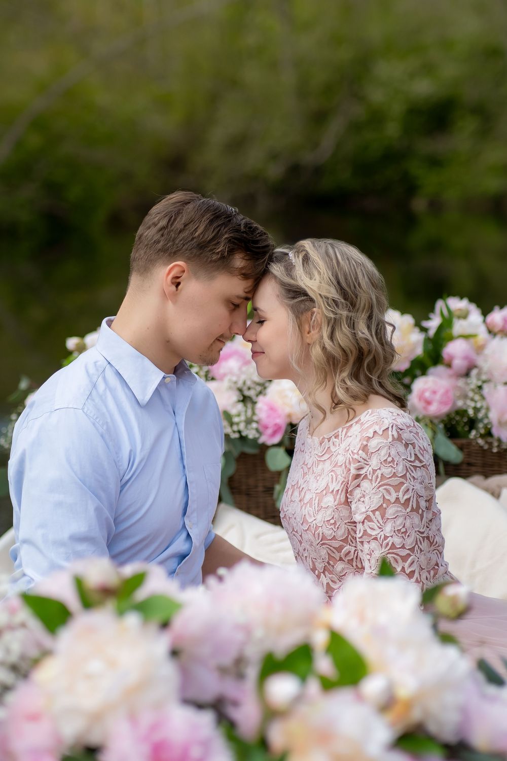 A romantic moment captured in a garden with blooming pink roses and white flowers in the foreground.