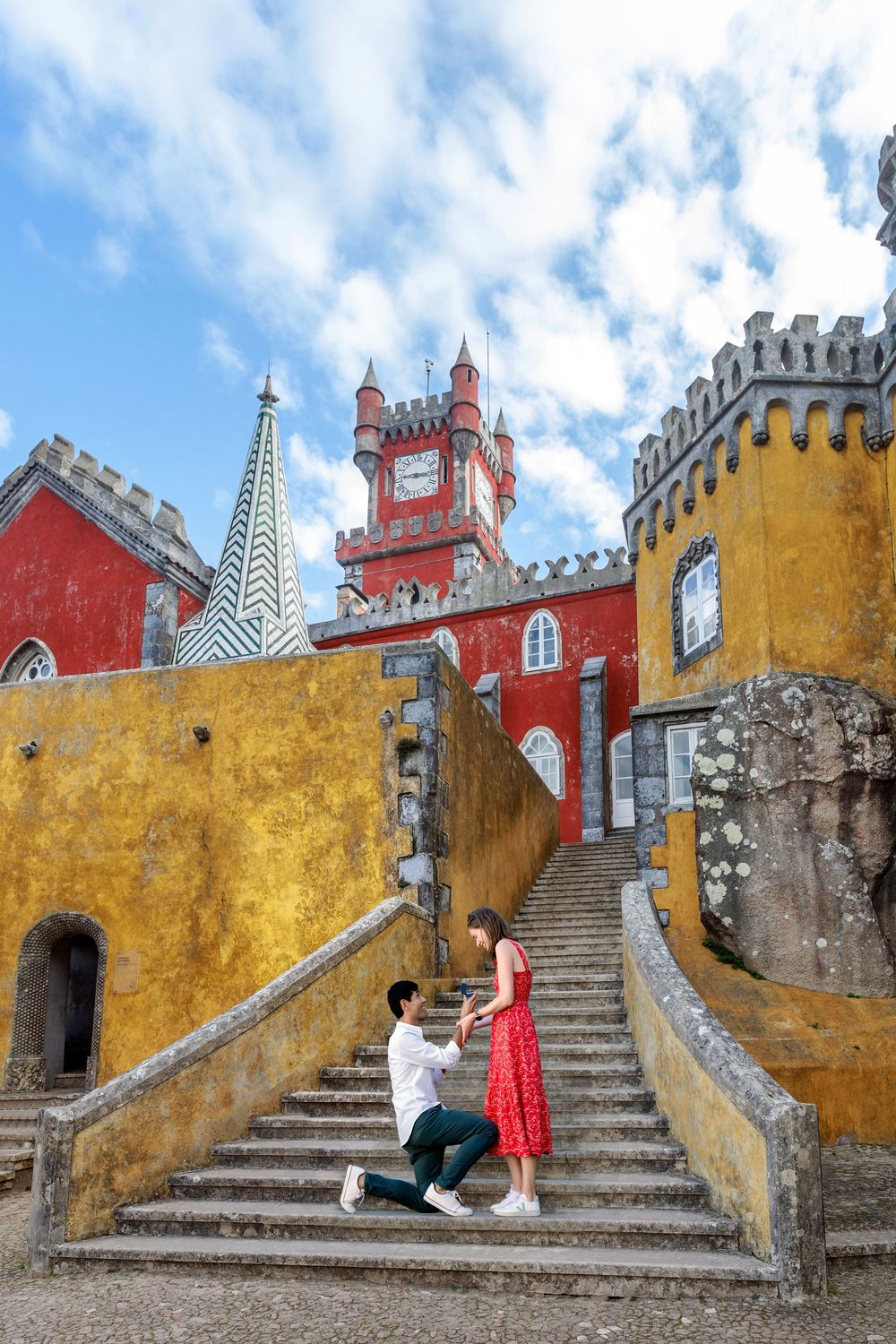 Stone staircase within the yellow and red Pena Palace walls in Sintra, Portugal displaying ornate architectural details.