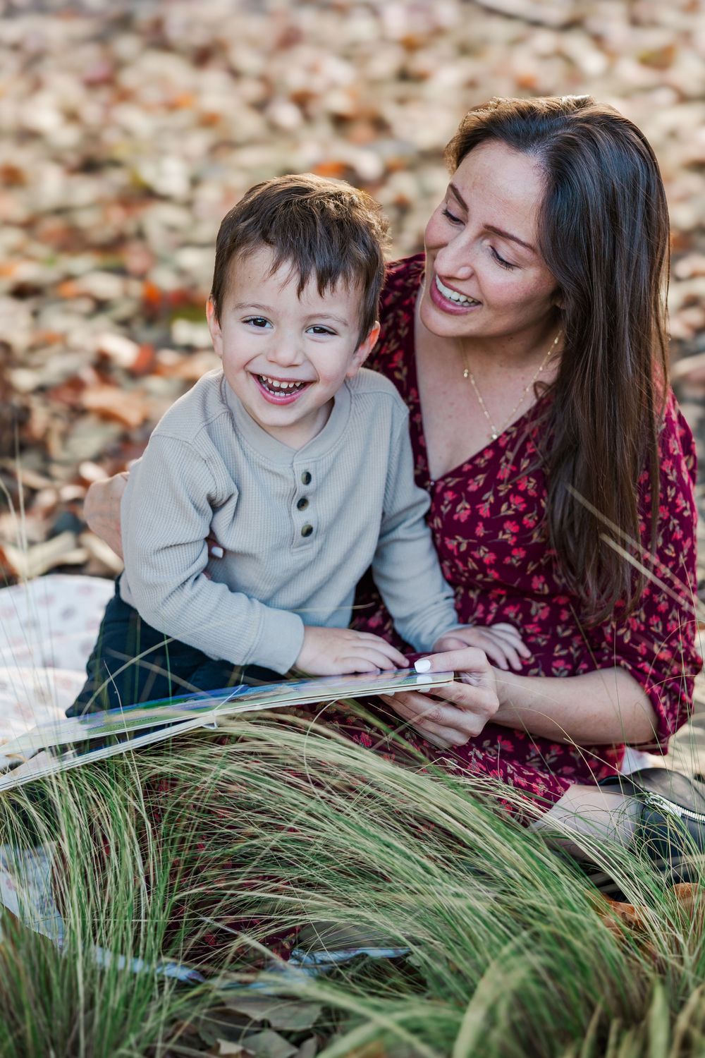 A heartwarming autumn scene with a family lying on fallen leaves while sharing a tender moment together.