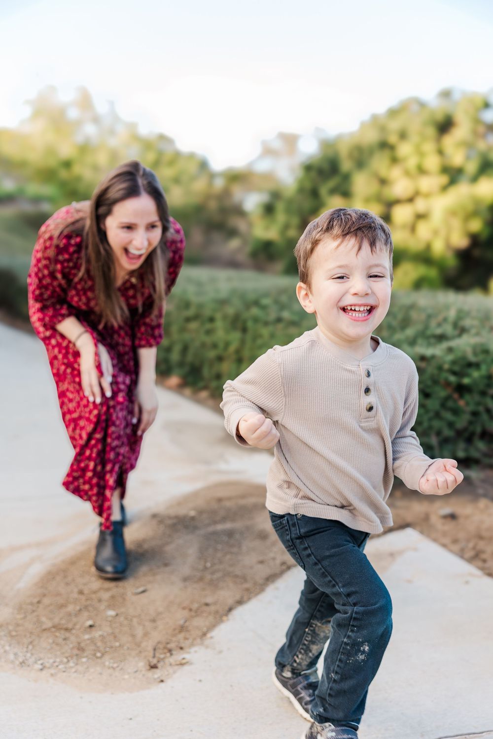 A playful scene outdoors with a beige sweater and red polka dot dress against a natural backdrop.