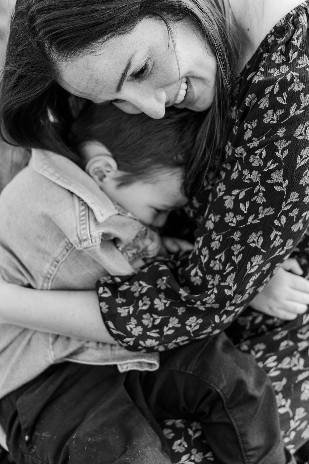 A tender black and white portrait showing an intimate embrace between two people wearing casual clothing.