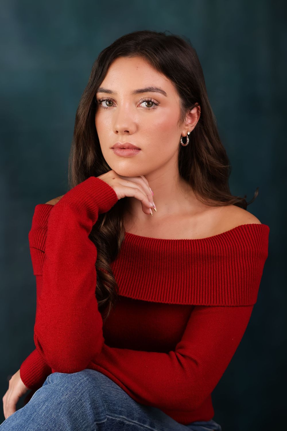 Four portraits of someone wearing a red off-shoulder sweater against a dark background with dramatic studio lighting.