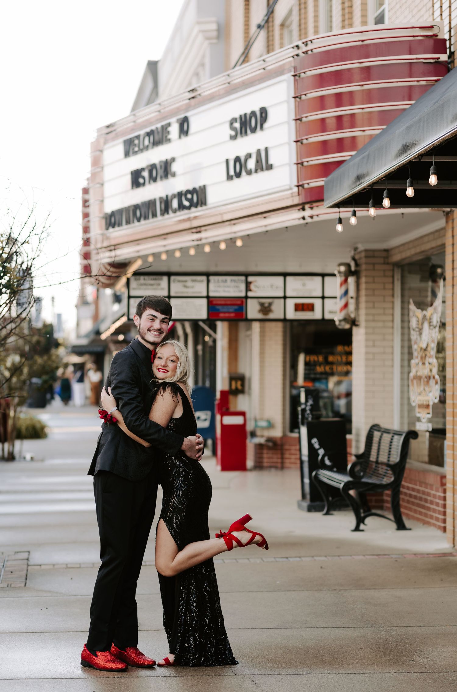 A couple shares a playful moment outside a local storefront.