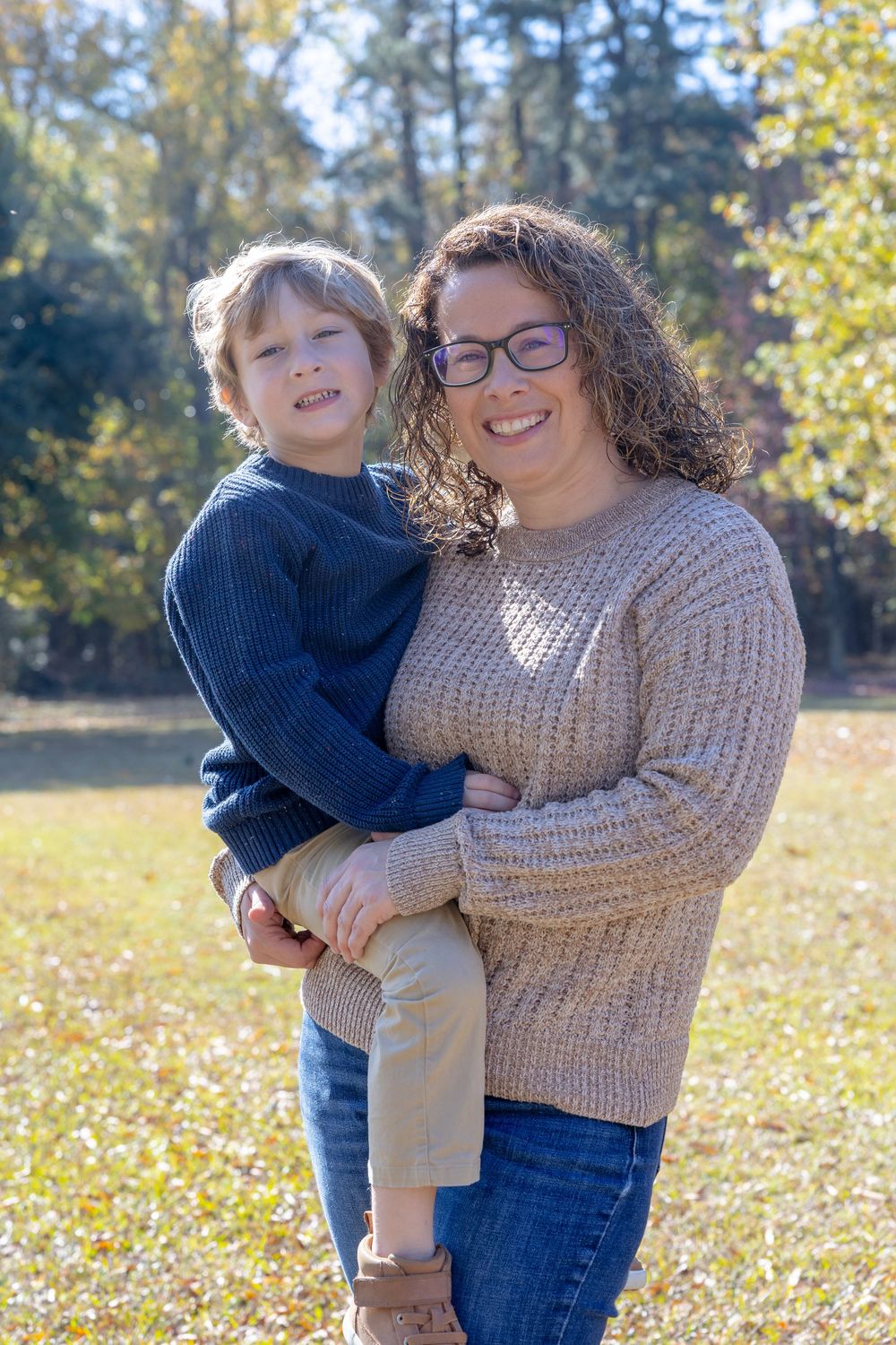 A heartwarming outdoor scene with two people embracing and smiling in a cozy autumn setting.