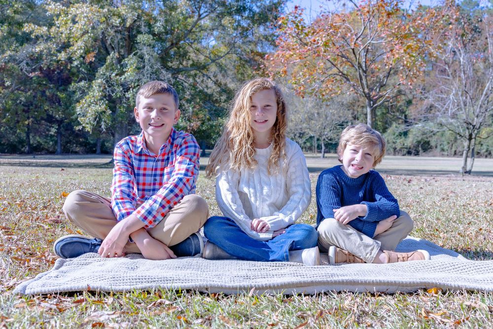 A collection of casual family photos taken outdoors on a sunny autumn day with fallen leaves.