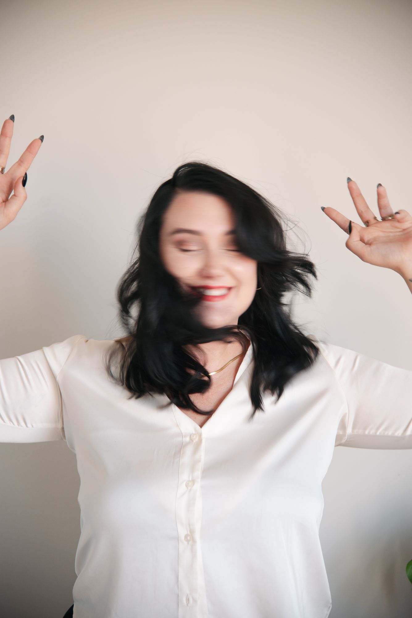 A sequence of five photos showing a person in a white sweater with dark hair expressing joyful movement against a neutral wall.