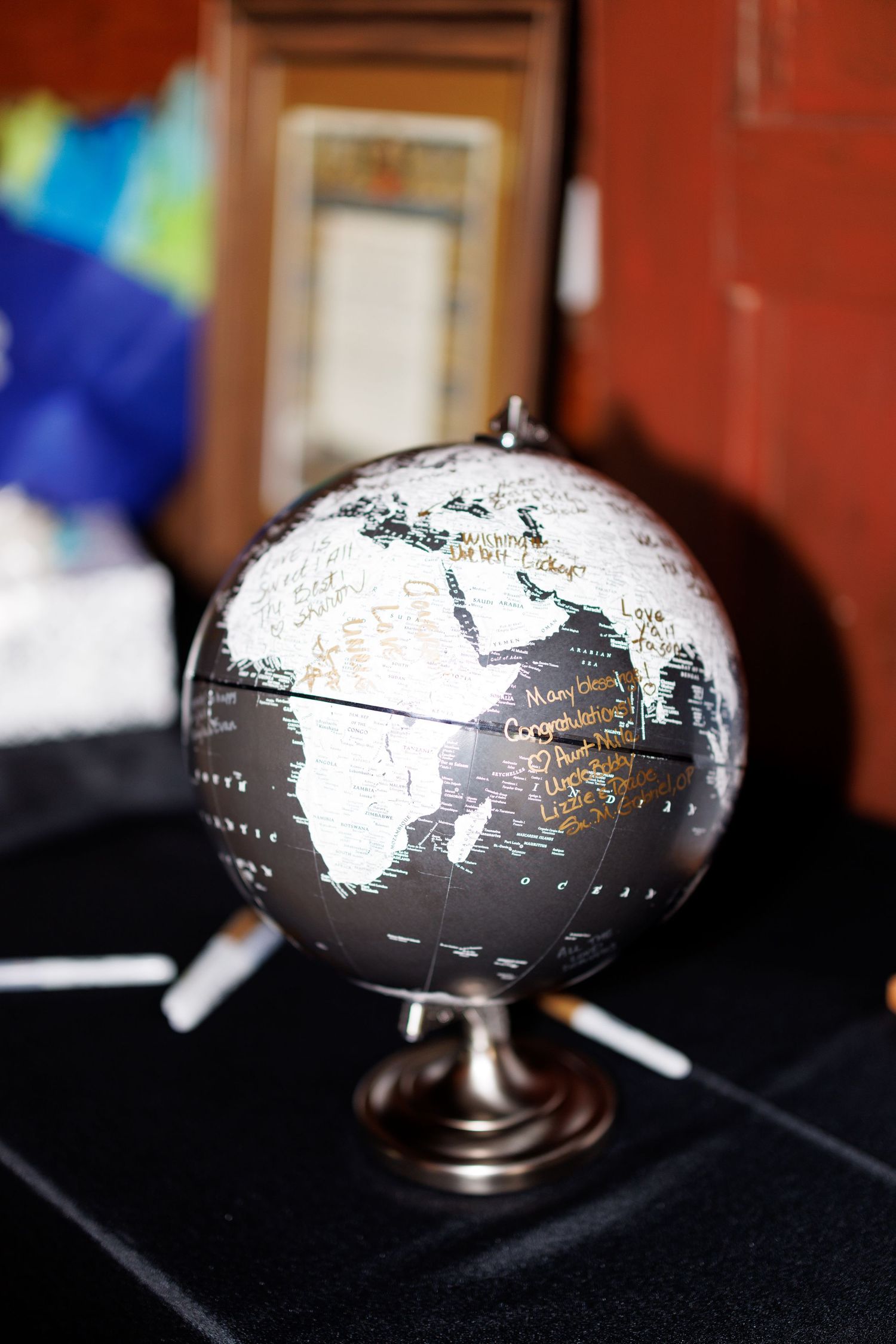 A decorative silver and white desktop globe sits on a dark surface.