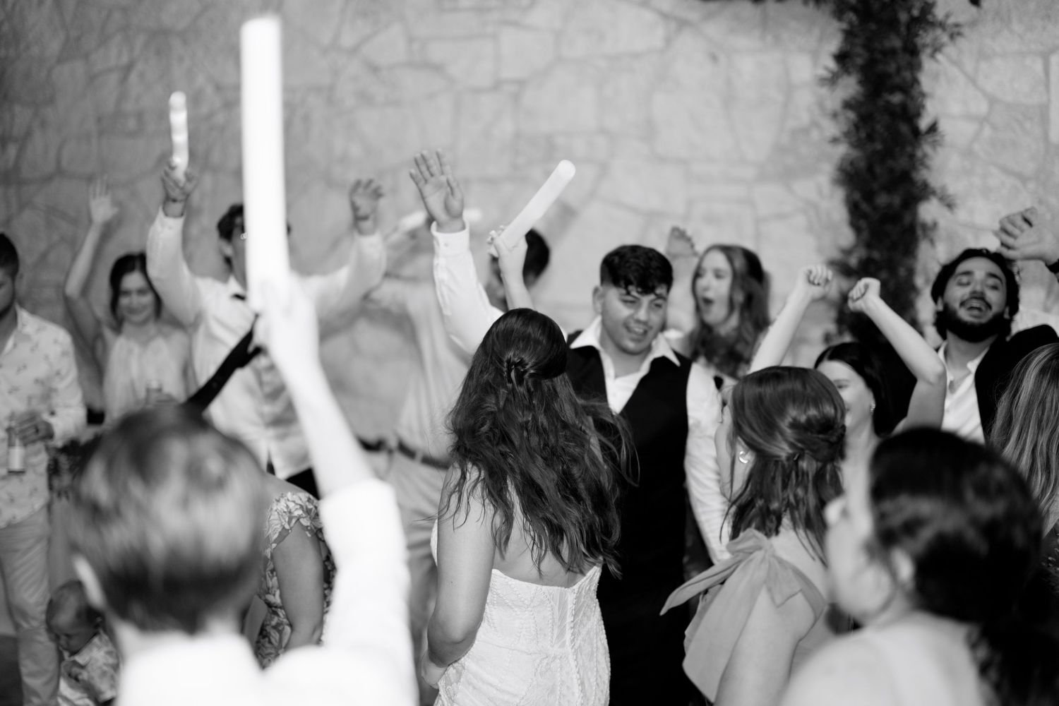 Wedding guests dance and celebrate on the dance floor at a reception venue.
