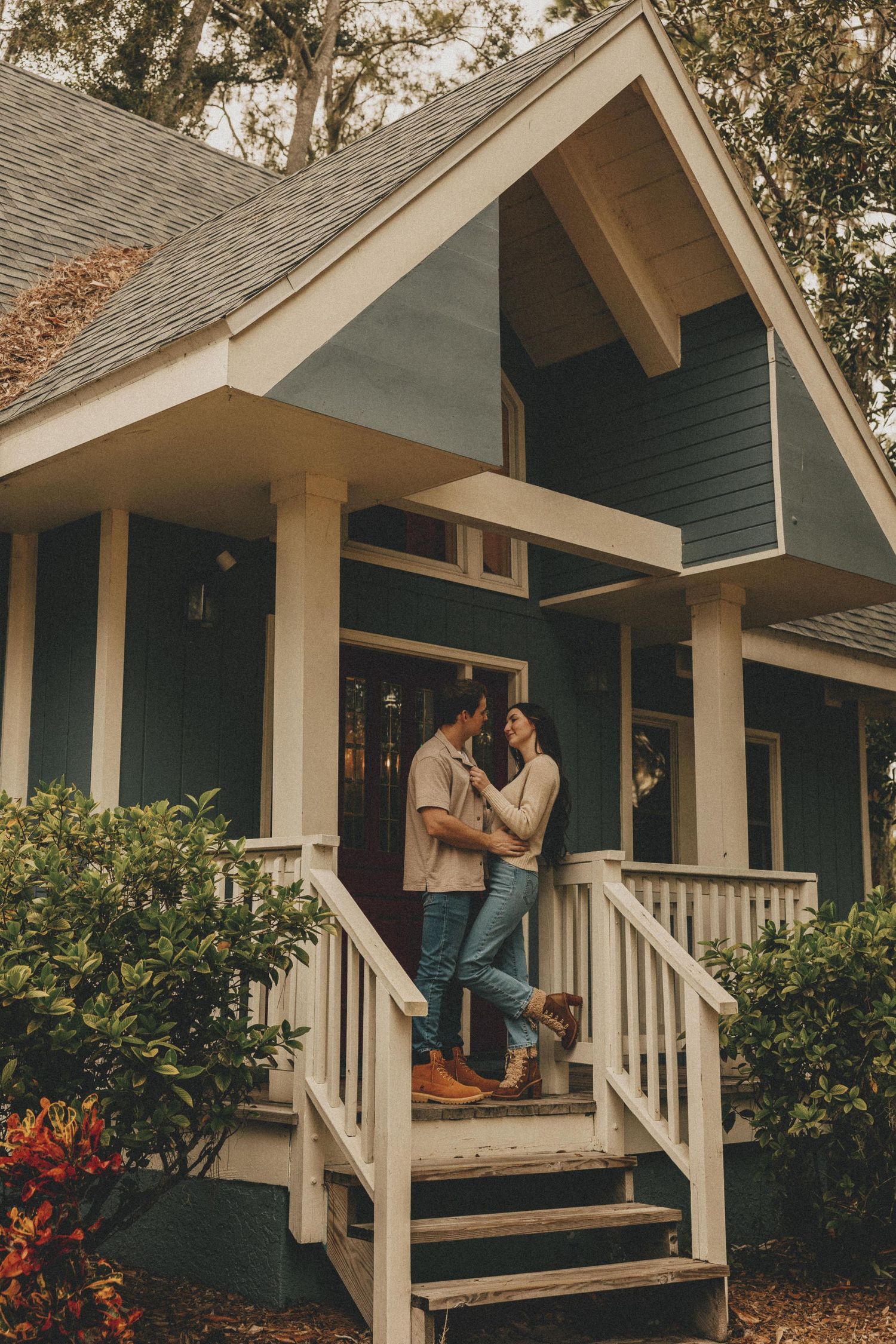 A series of five connected photos showing a couple sharing romantic moments on the front porch of a blue cottage.