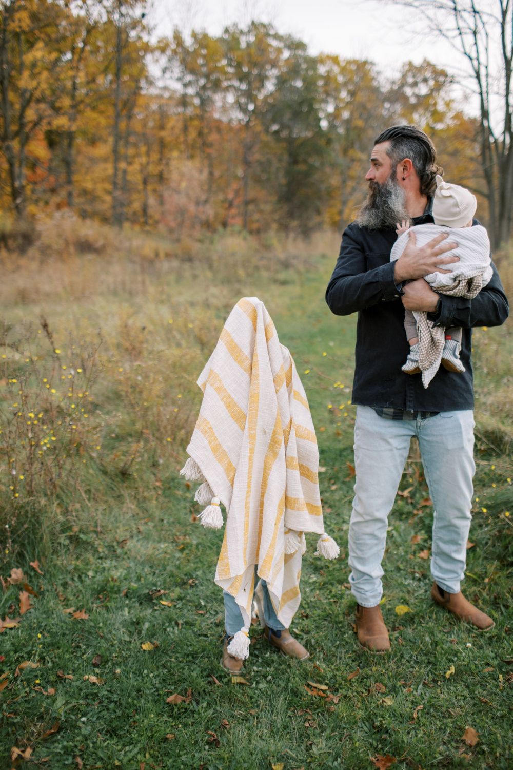 A series of outdoor family photos showing playful moments in an autumn field with yellow striped blankets.