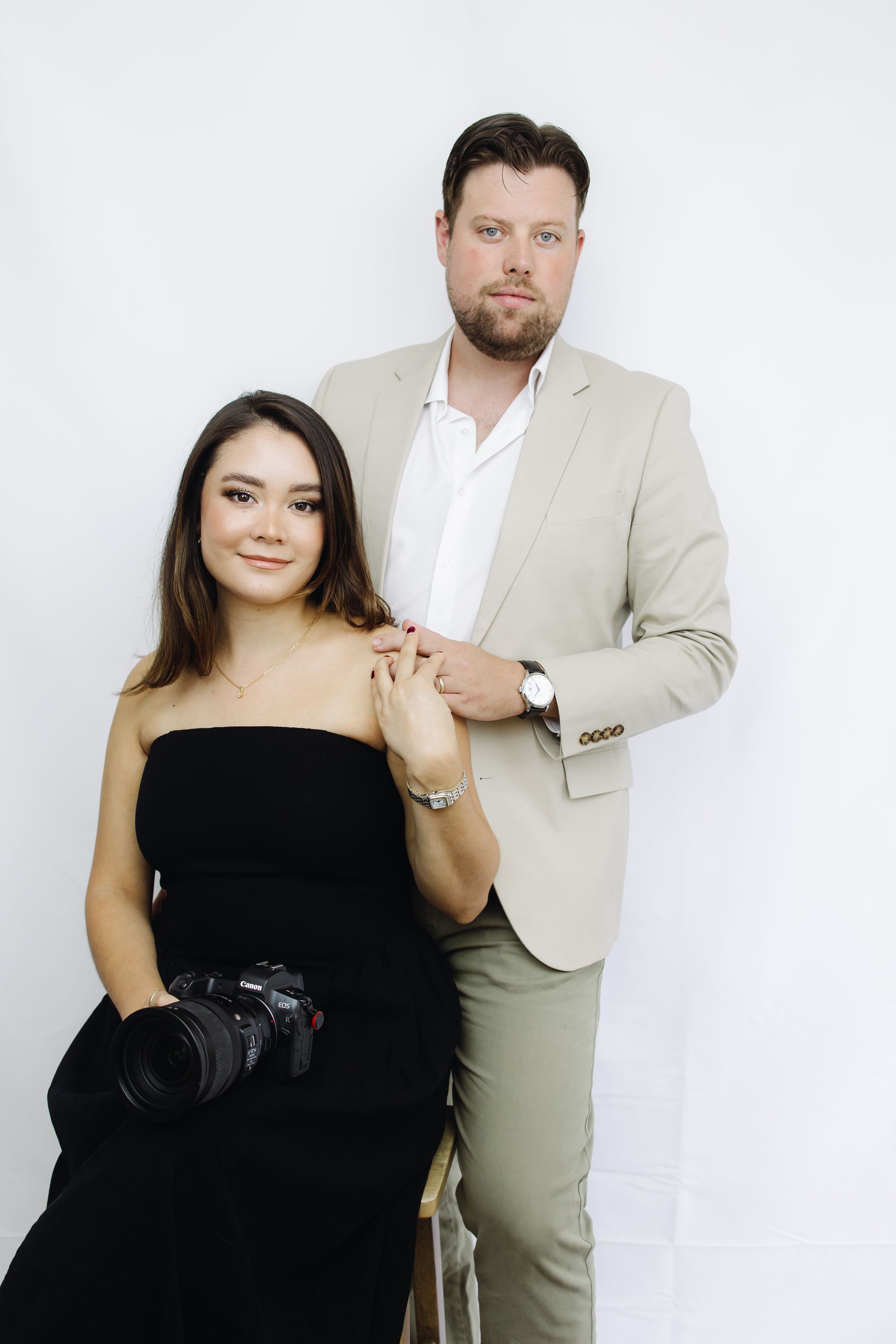 Professional studio portrait series showing a couple posing against white background in elegant black and beige attire.