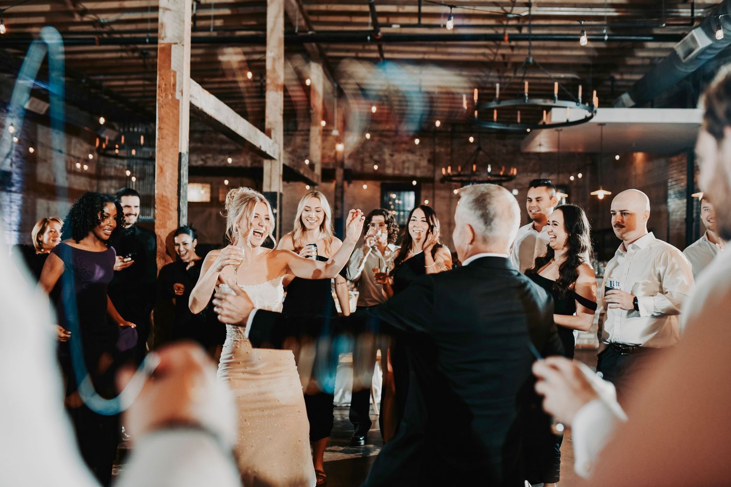 Groom twirling his bride during the first dance at Brake & Clutch Warehouse.