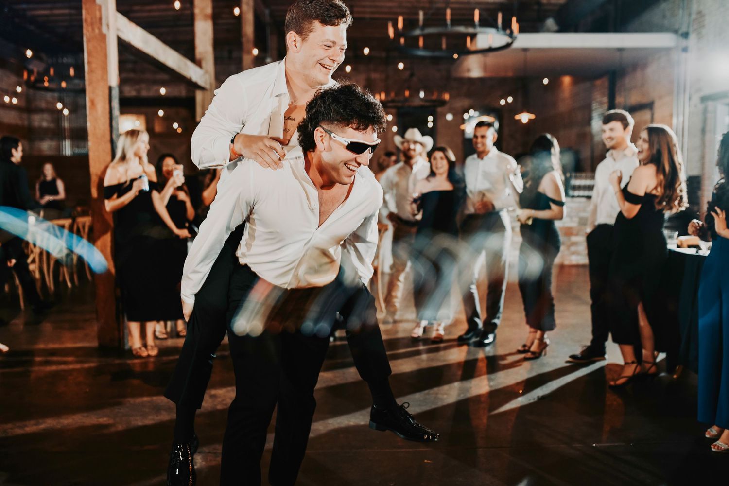Chic, fashion-inspired first dance portrait with the couple illuminated by modern reception lighting.