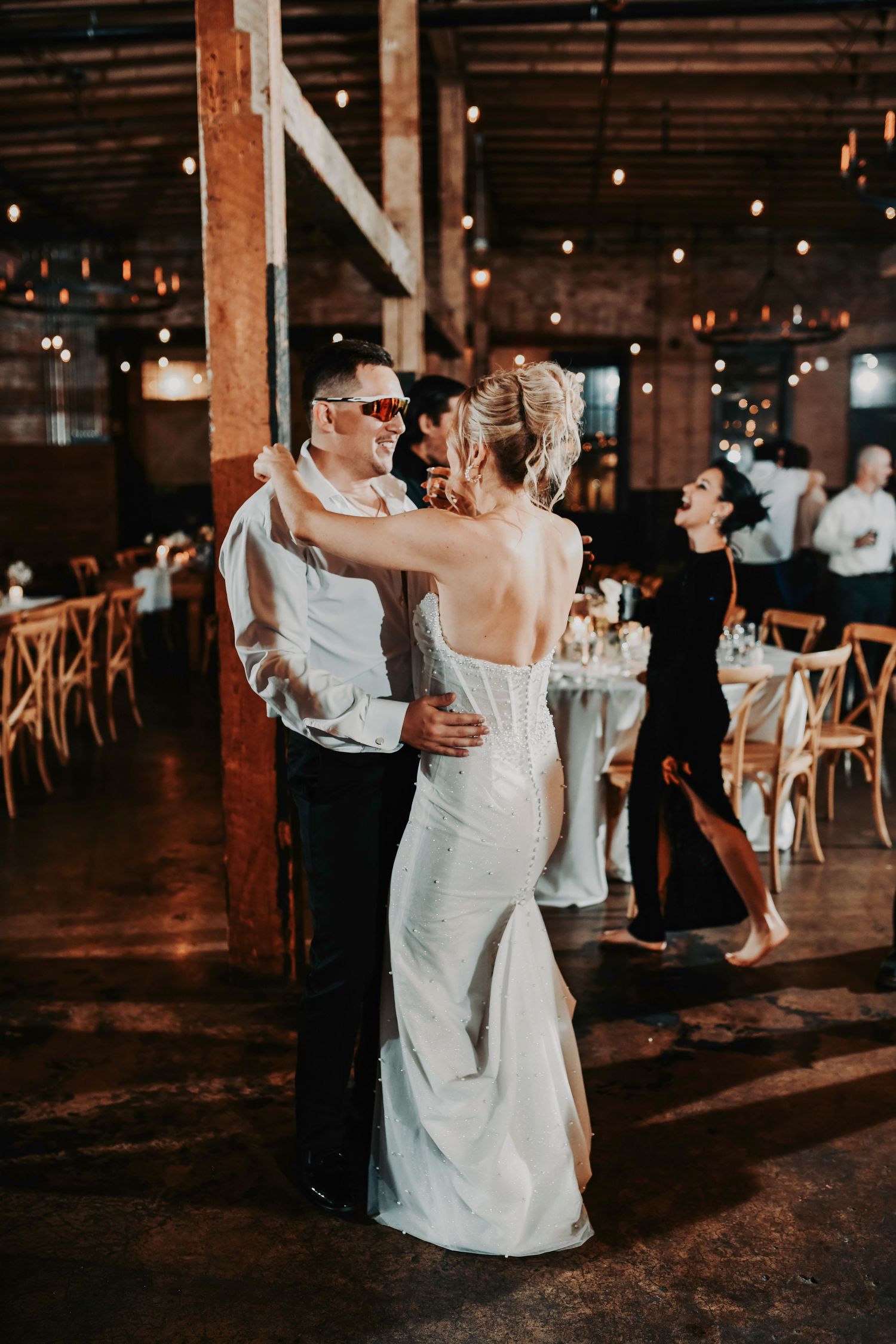 Sweet candid moment of the groom pulling his bride close during their first dance.