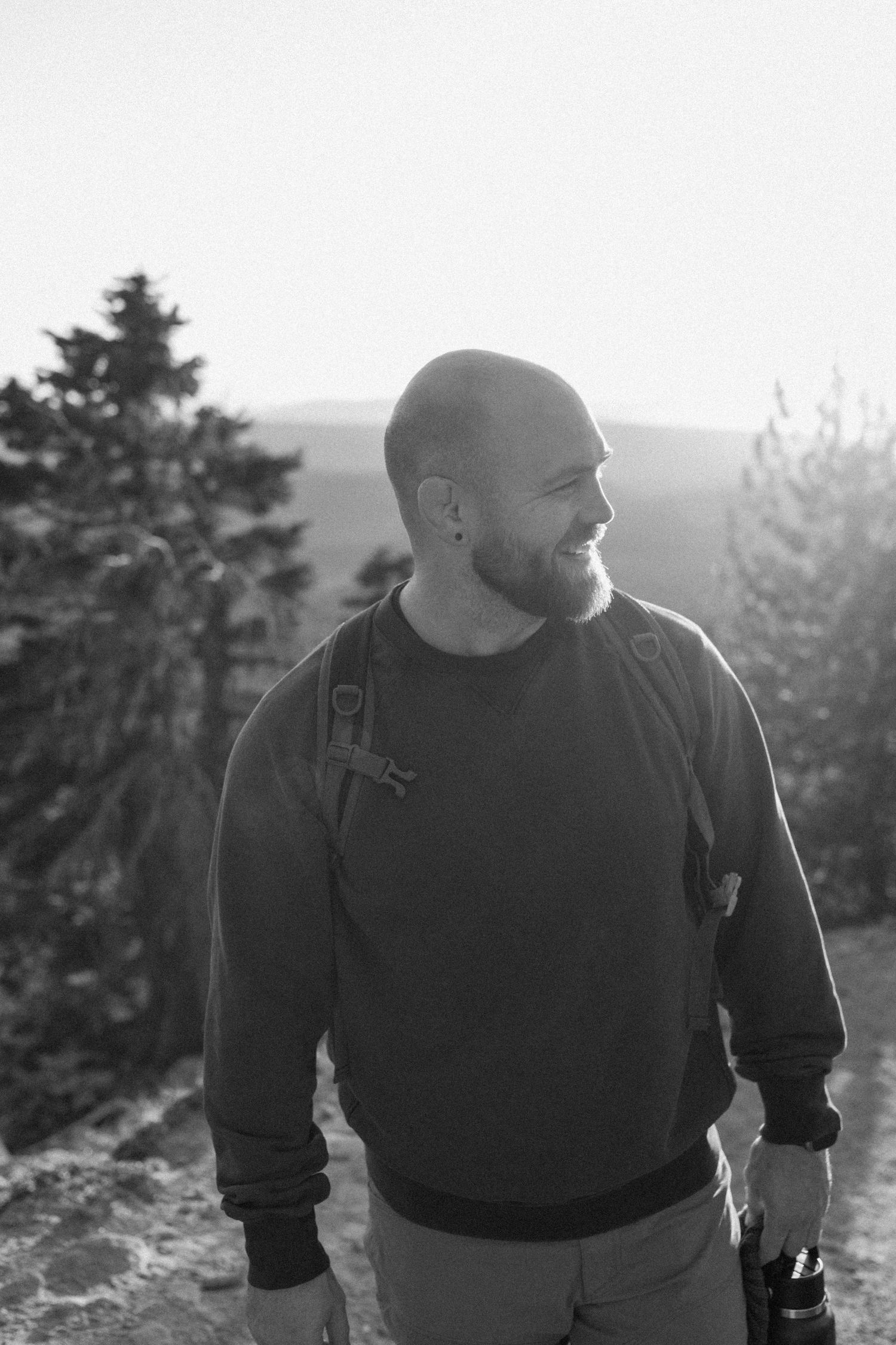 Silhouette of person in dark clothing against natural outdoor background.