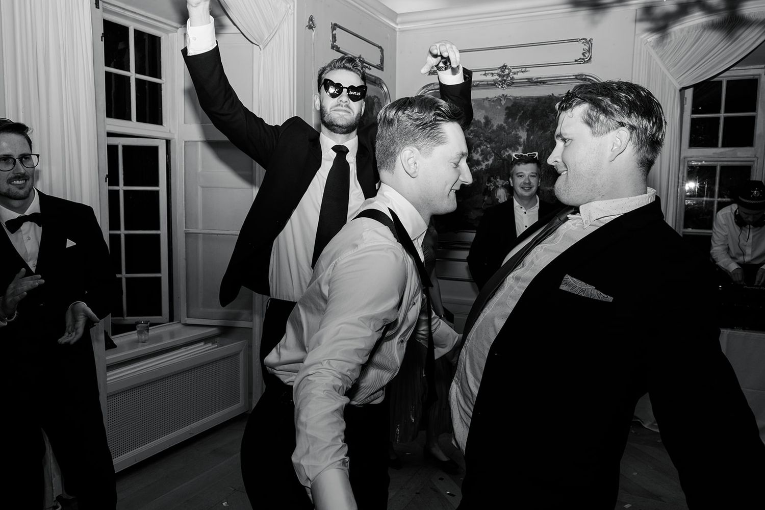 Black and white photo of a group of people in formal attire at what appears to be a social gathering or party.