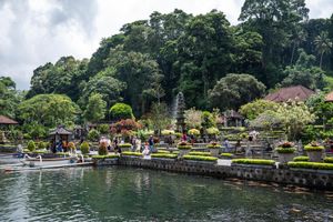 Tirta Gangga water palace in Bali, Indonesia, featuring ornate fountains, lush tropical gardens, and serene reflecting pools.