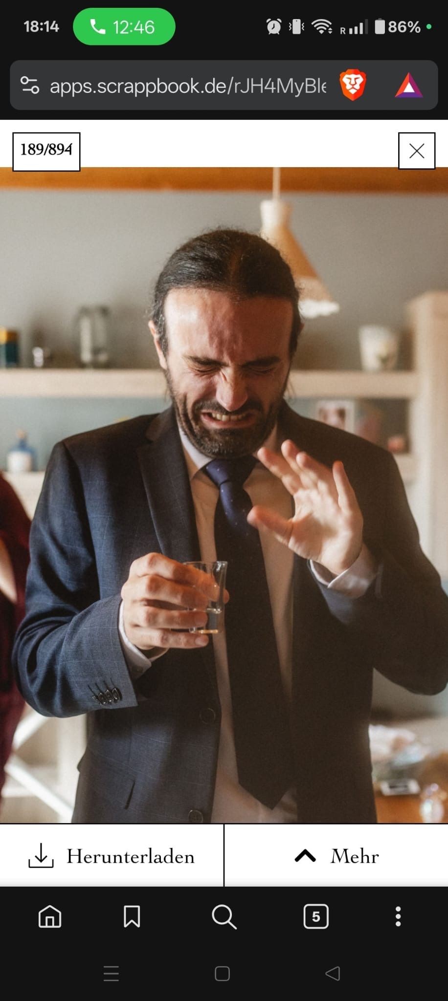 Man in suit reacting with disgust while holding a glass at a wedding reception indoors.