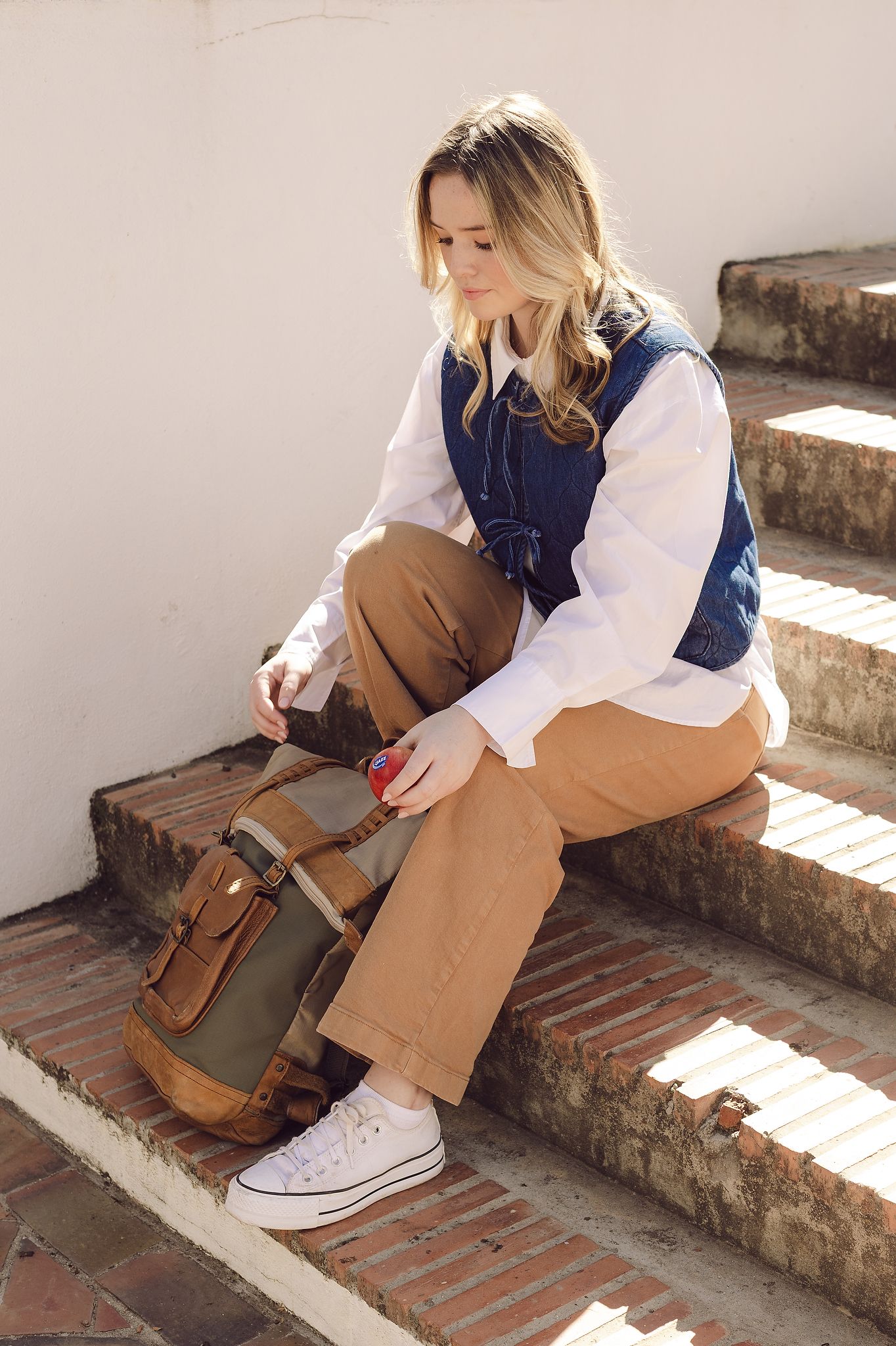 Young woman sitting on steps with Jazz Apple