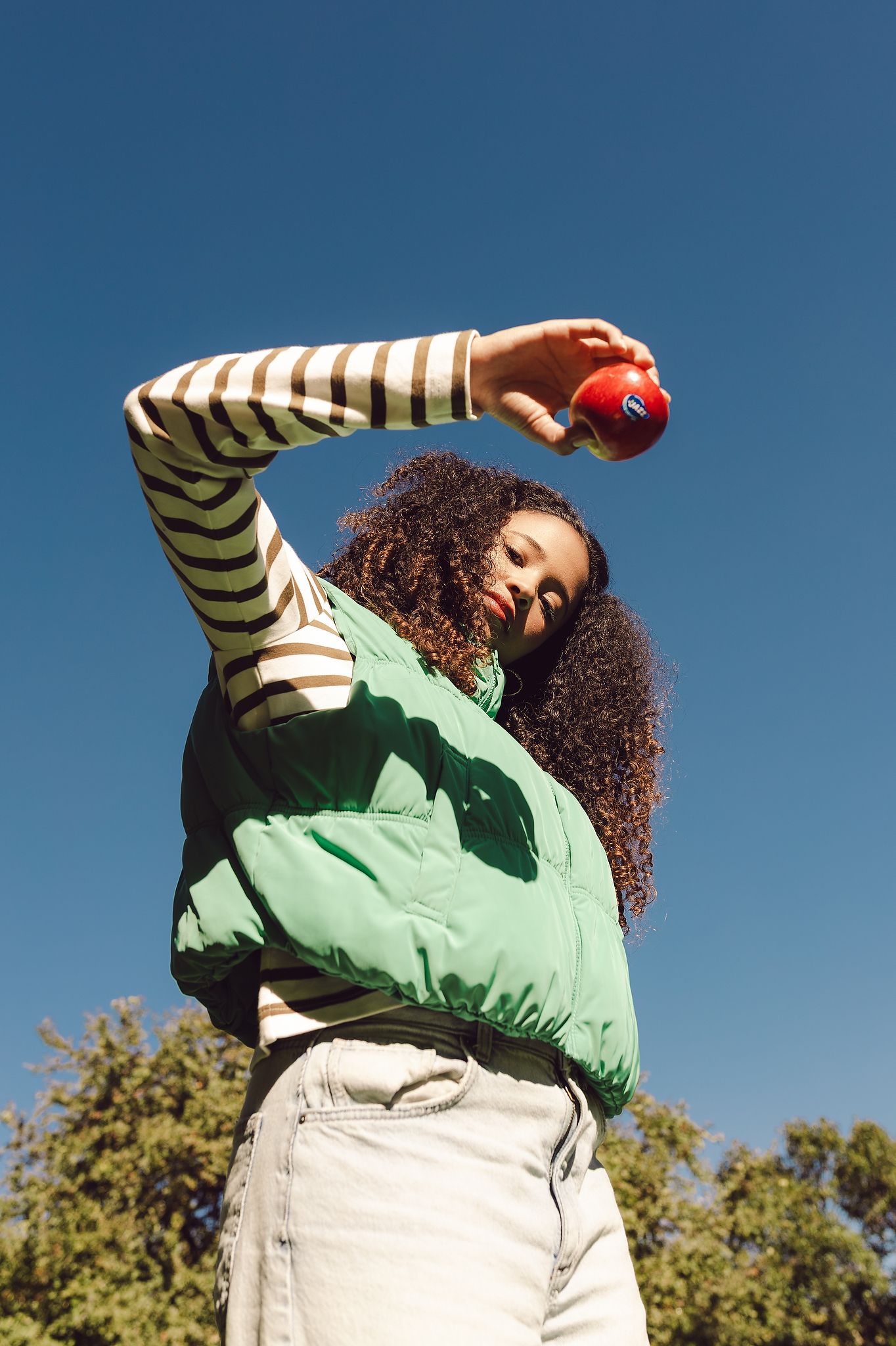 Shot from bottom of woman holding a Jazz Apple outside
