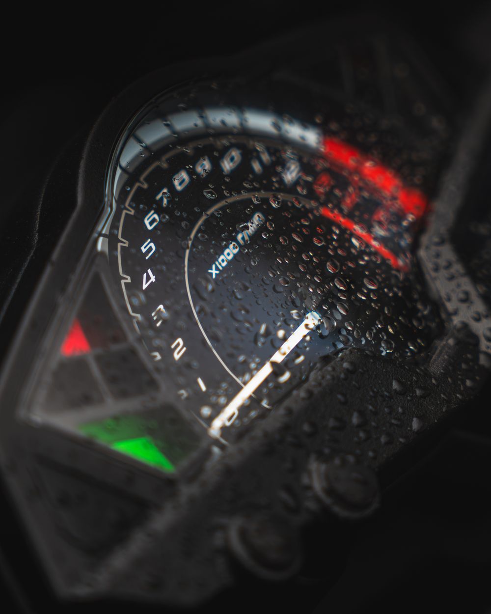 Motorcycle dashboard photographed in the rain