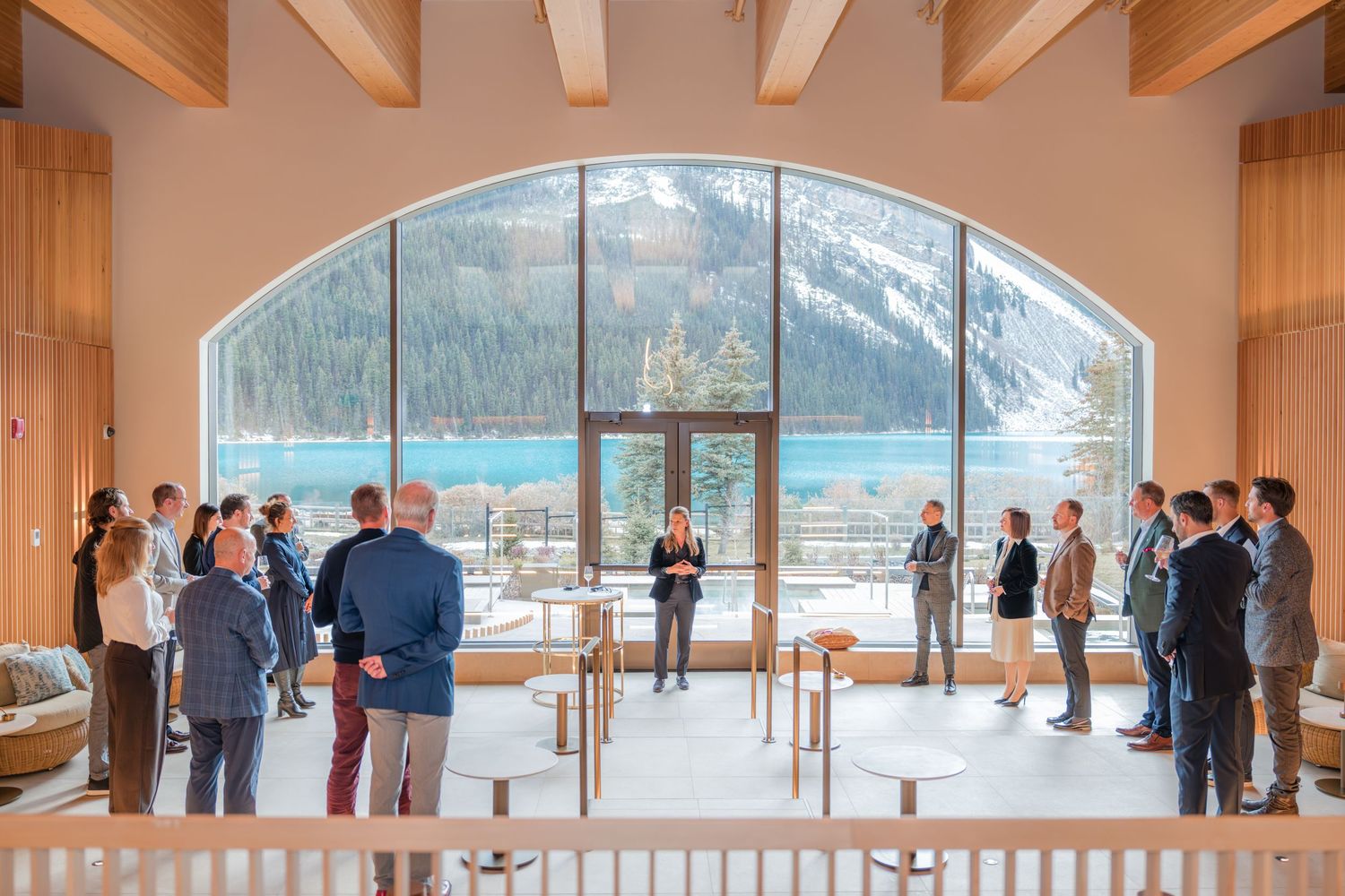 Group gathering in BASIN Fairmont Chateau Lake Louise with panoramic views of turquoise lake and snow-capped peaks.