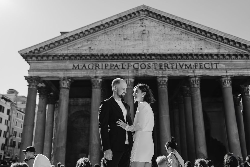 Couple embracing in front of the Pantheon in Rome, Italy, in a black and white wedding photo.