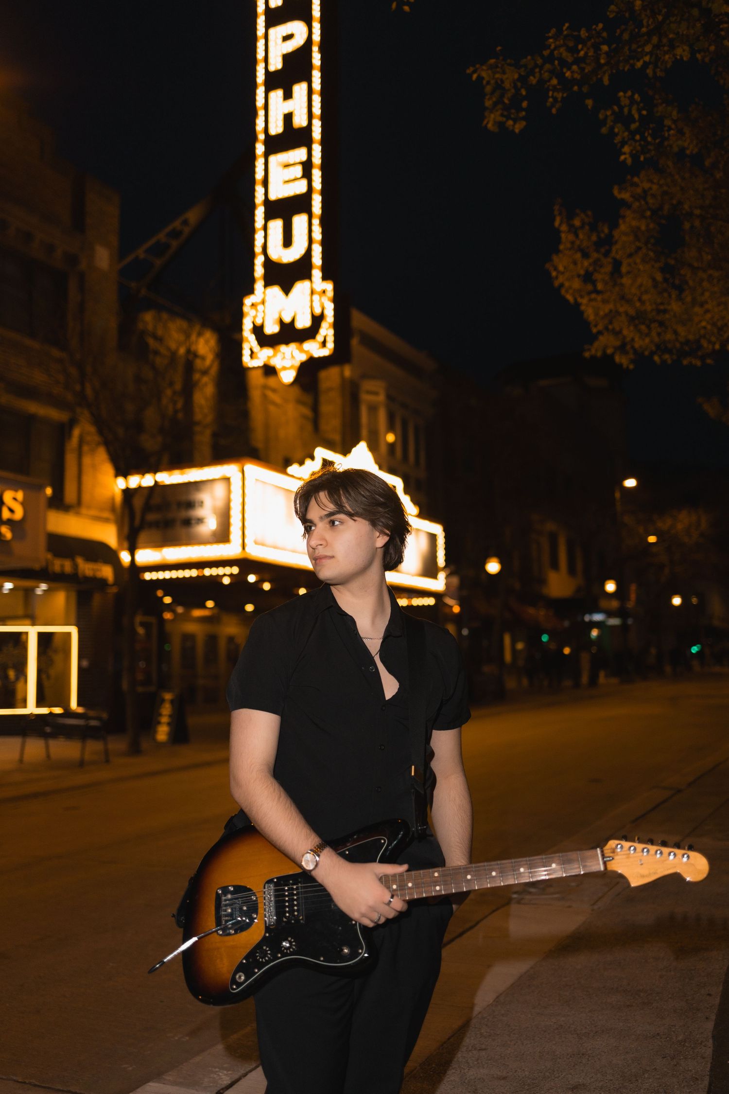 best high school senior photo locations in madison wi downtown state street orpheum sign lights electric guitar urban vibe city musician pic
