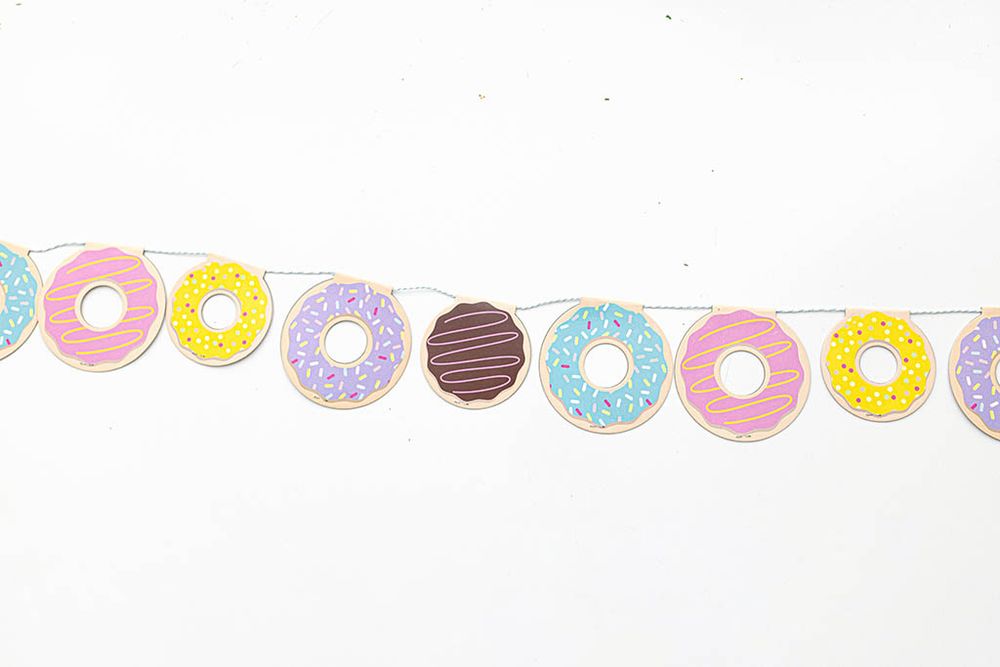 Colorful donut garland banner with pink, purple, teal, and yellow frosted donuts.