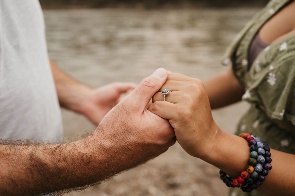couple holds hands and showcases beautiful engagement ring