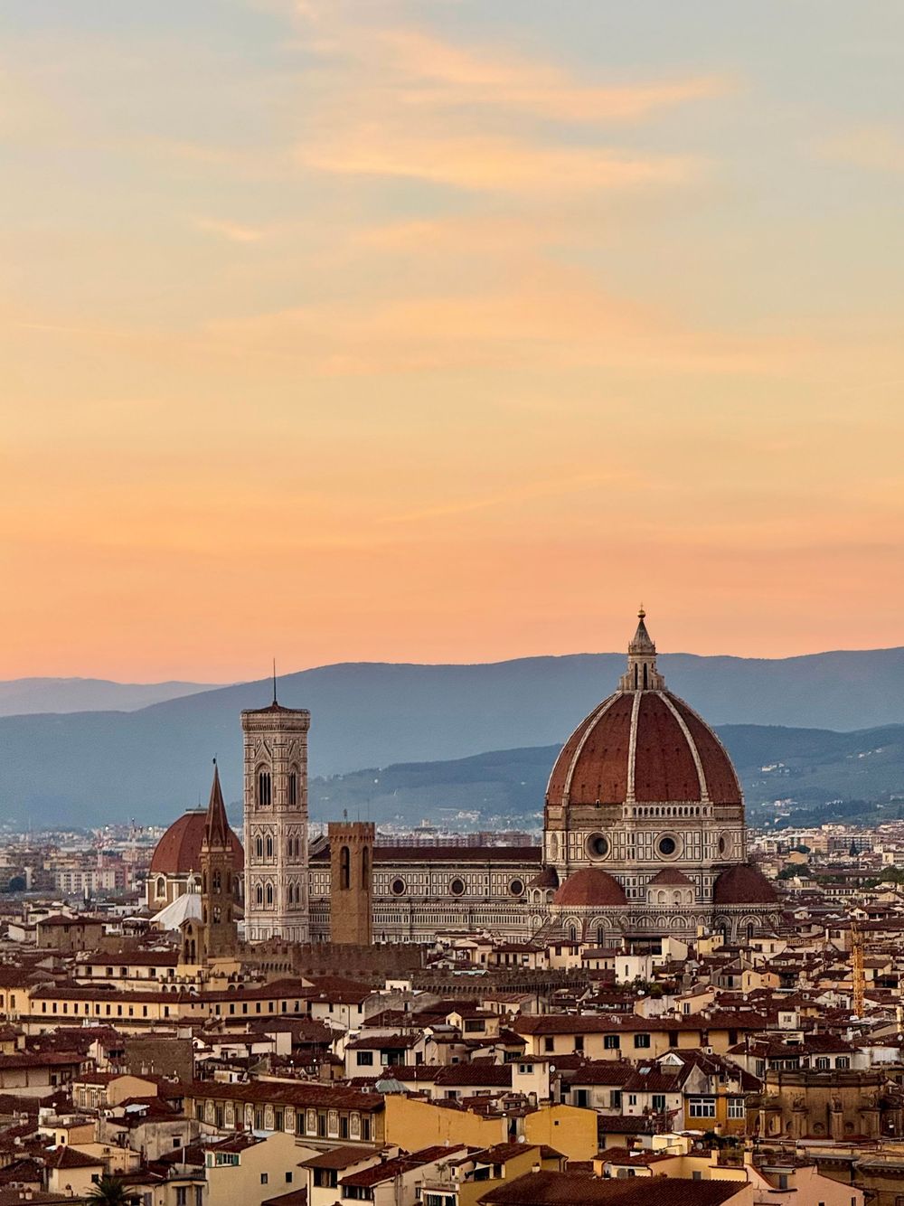 Florence Cathedral Santa Maria del Fiore with Brunelleschi dome and Giotto bell tower at golden sunset over the city.