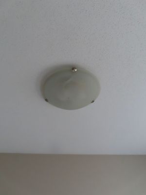 Flush mount frosted glass ceiling light fixture with brushed nickel hardware on a white textured ceiling.