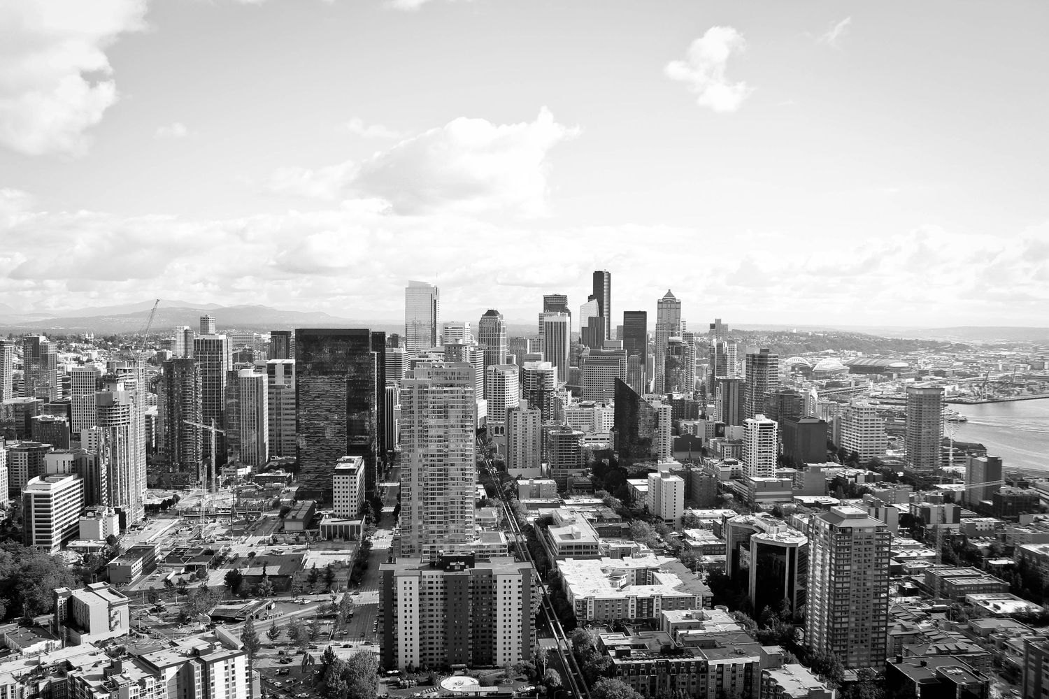 Black and white aerial view of Seattle's downtown skyline showing dense urban architecture.