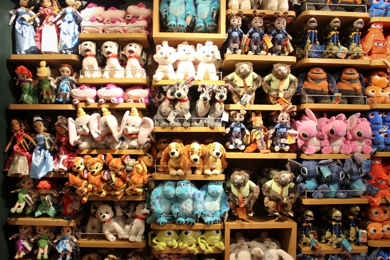Colorful display of Disney plush toys and stuffed animals arranged on retail shelves.