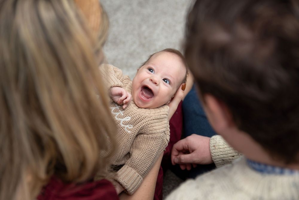 Baby so happy to be held by mama with a huge smile.